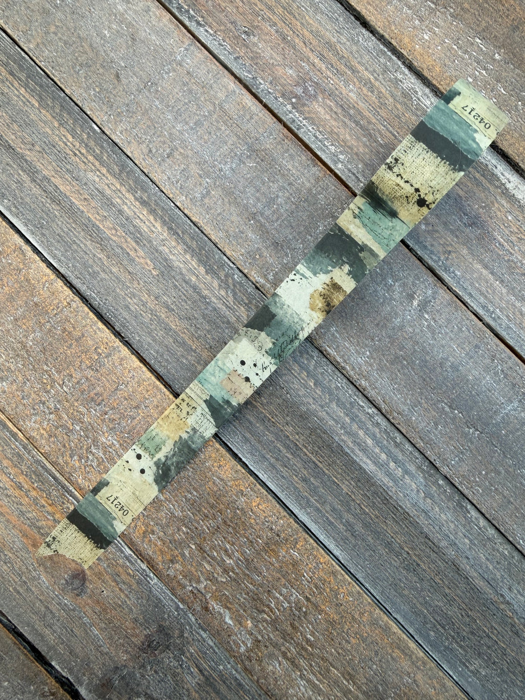Field Notes washi tape unrolled showing deep teal brush patches and weathered paper