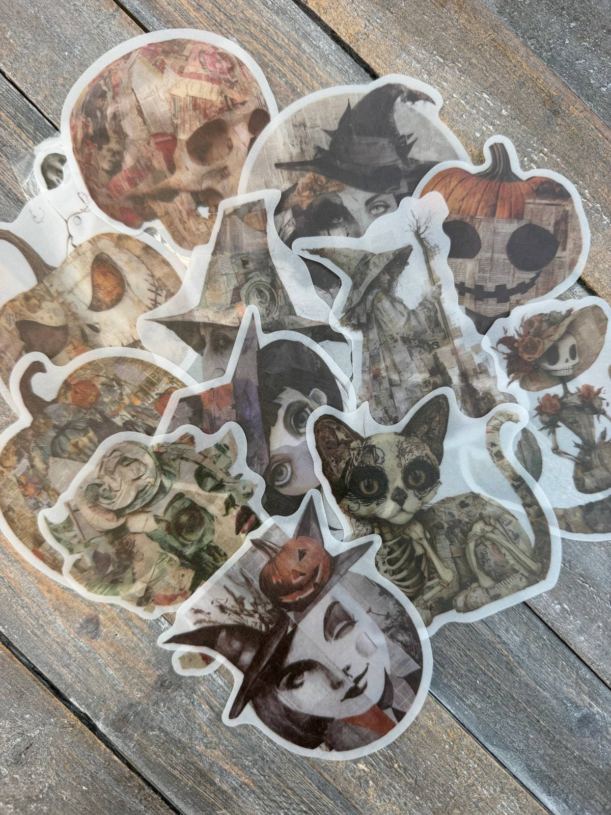 Vellum After Dark Paper Bites — pile of translucent vellum die cuts showing skulls, witches, jack-o-lanterns, a skeleton cat and ghostly faces on a weathered wood surface